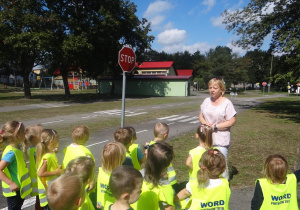 Nauczycielka przedstawia dzieciom znaki drogowe